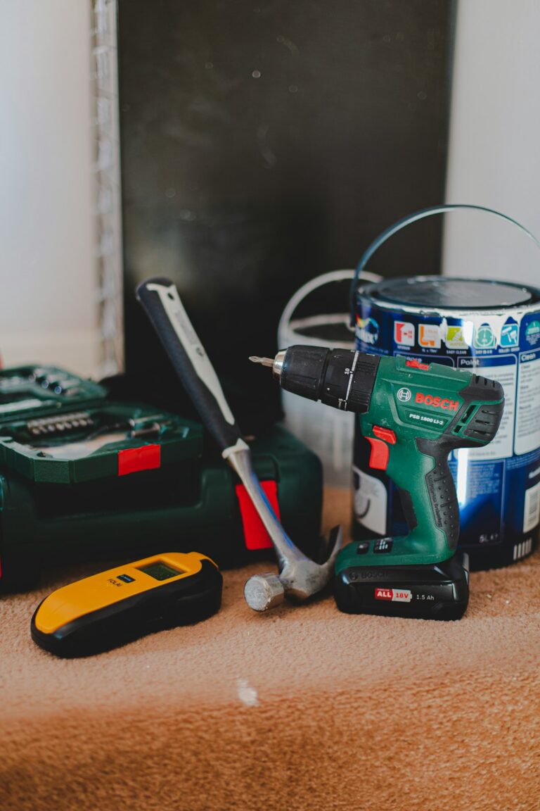 Contractor in work attire using basic hand tools inside a commercial building maintenance area.